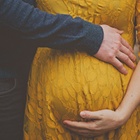 image of a pregnant woman and her partner touching her stomach